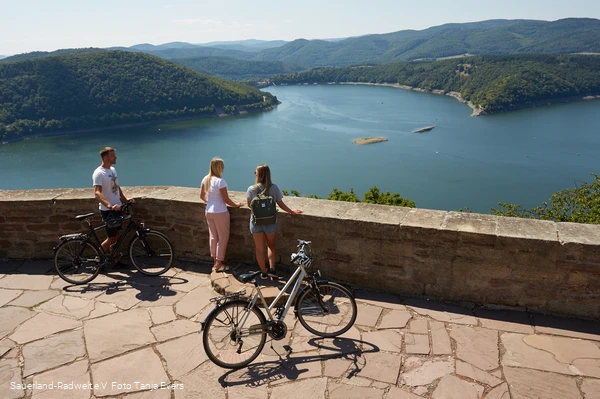 Drei Radfahrer blicken auf den Edersee vom Schloss Waldeck