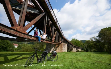 Zwei Radfahrer sitzen auf der Fischbauchbrücke Foto: Paul Masukowitz